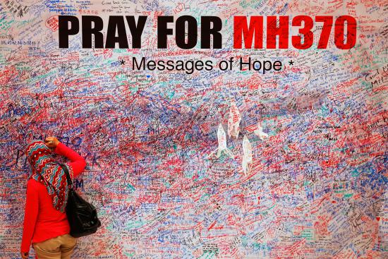 A woman leaves message of support and hope for passengers of missing Malaysia Airlines MH370 in central Kuala Lumpur