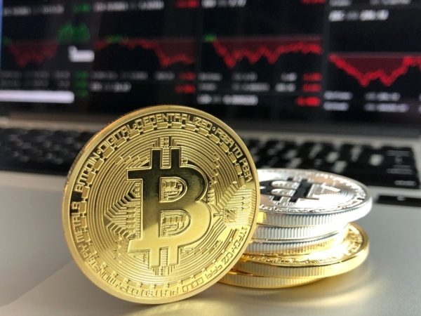 Bitcoin cryptocurrency next to computer | DeviceDaily.com