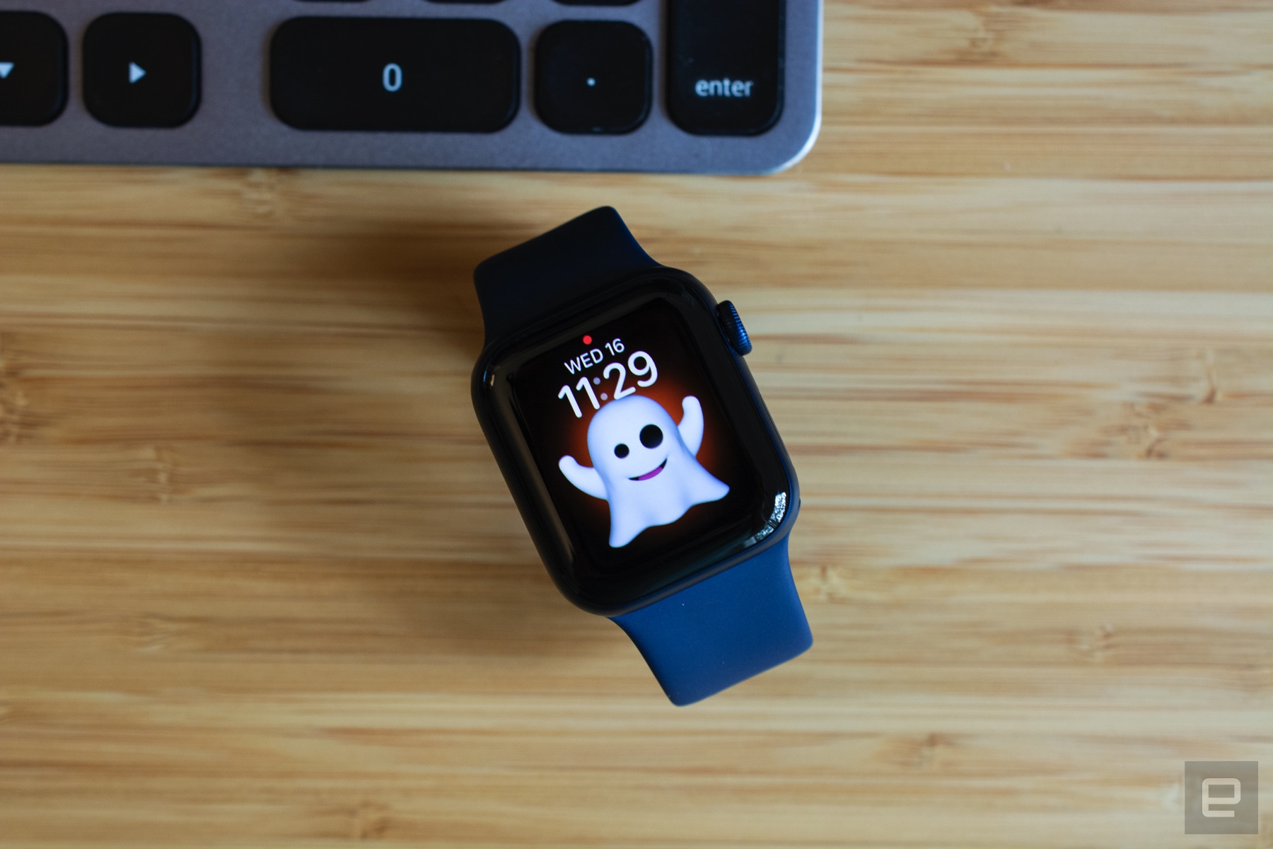 The Apple Watch Series 6 with a Memoji watch face sitting on a wooden table. | DeviceDaily.com