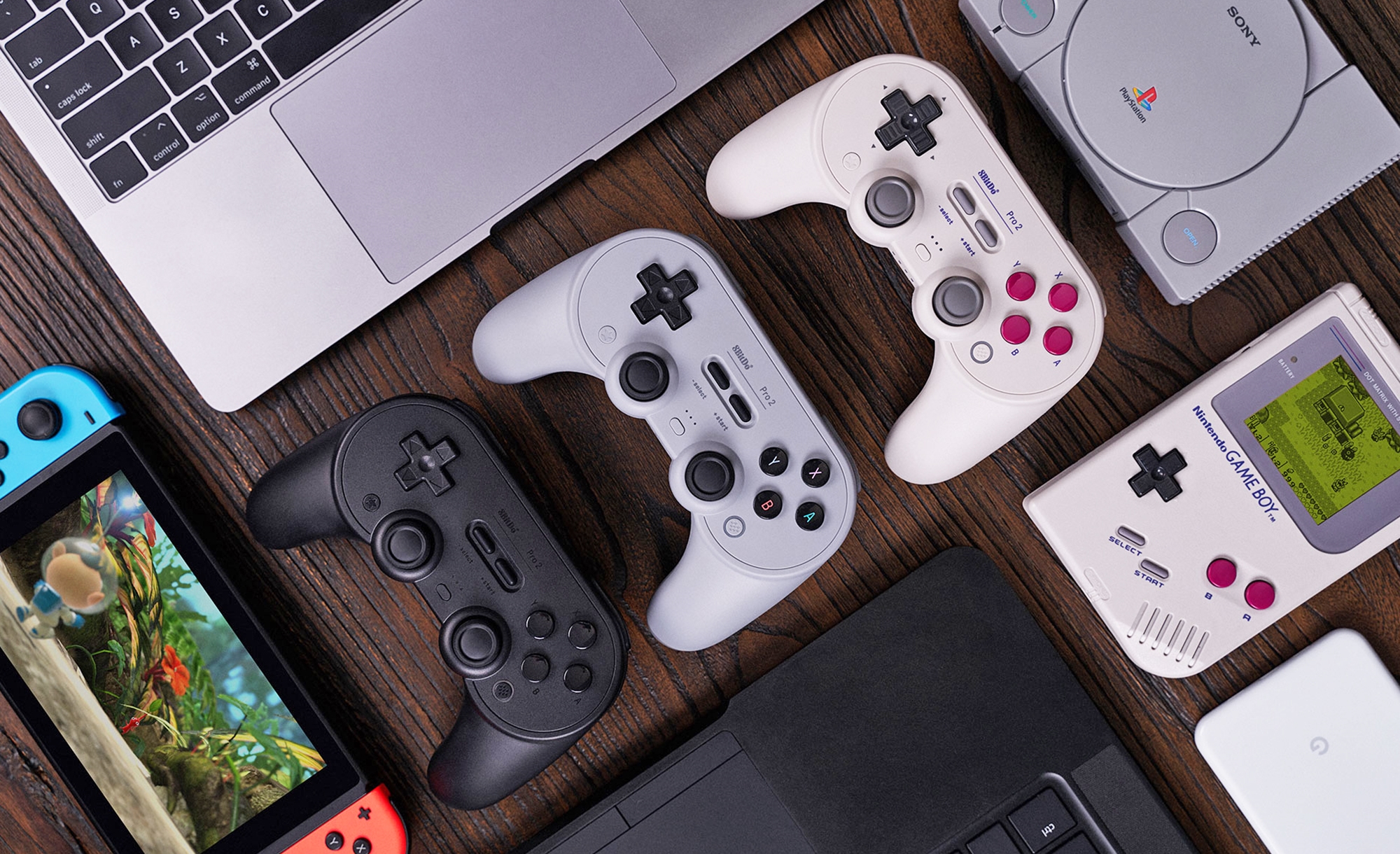 An overview photo of the 8BitDo Pro 2 gaming controller lined up neatly next to a variety of compatible game platforms. | DeviceDaily.com