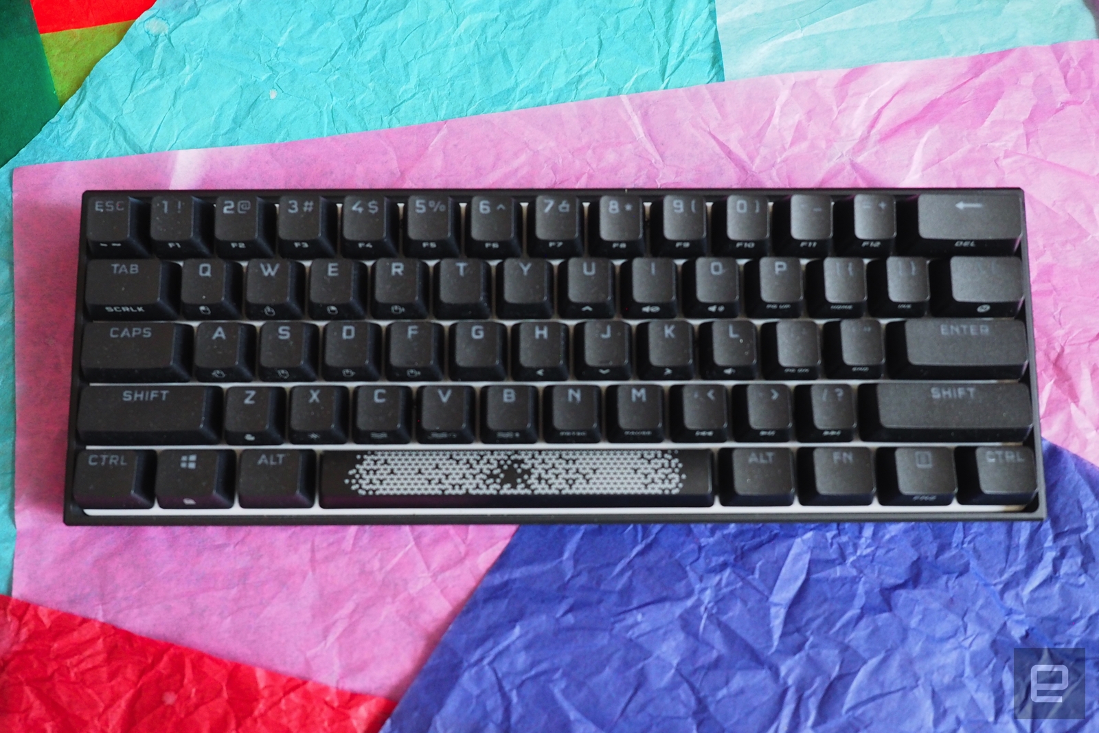 Corsair K65 RGB Mini in black on a bed of colored paper | DeviceDaily.com