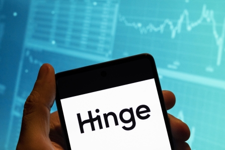CHINA - 2023/02/19: In this photo illustration, the online dating app Hinge logo is seen displayed on a smartphone with an economic stock exchange index graph in the background. (Photo Illustration by Budrul Chukrut/SOPA Images/LightRocket via Getty Images)