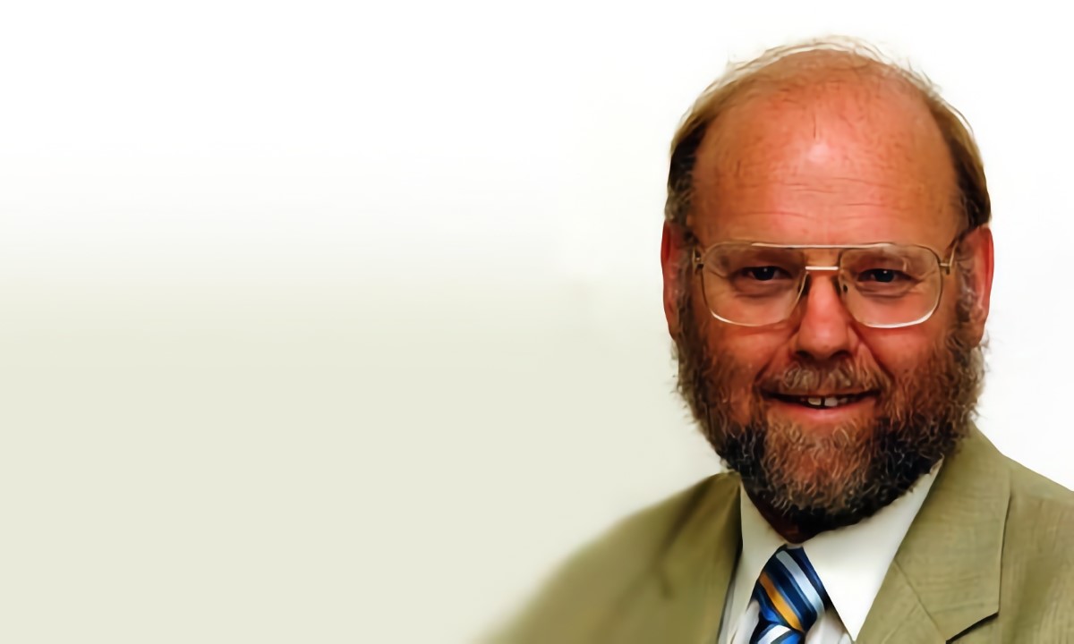 Portrait of Sir Ian Wilmut, the cloner of Dolly the sheep. The bearded man with glasses smiles for the camera over an off-white background. | DeviceDaily.com